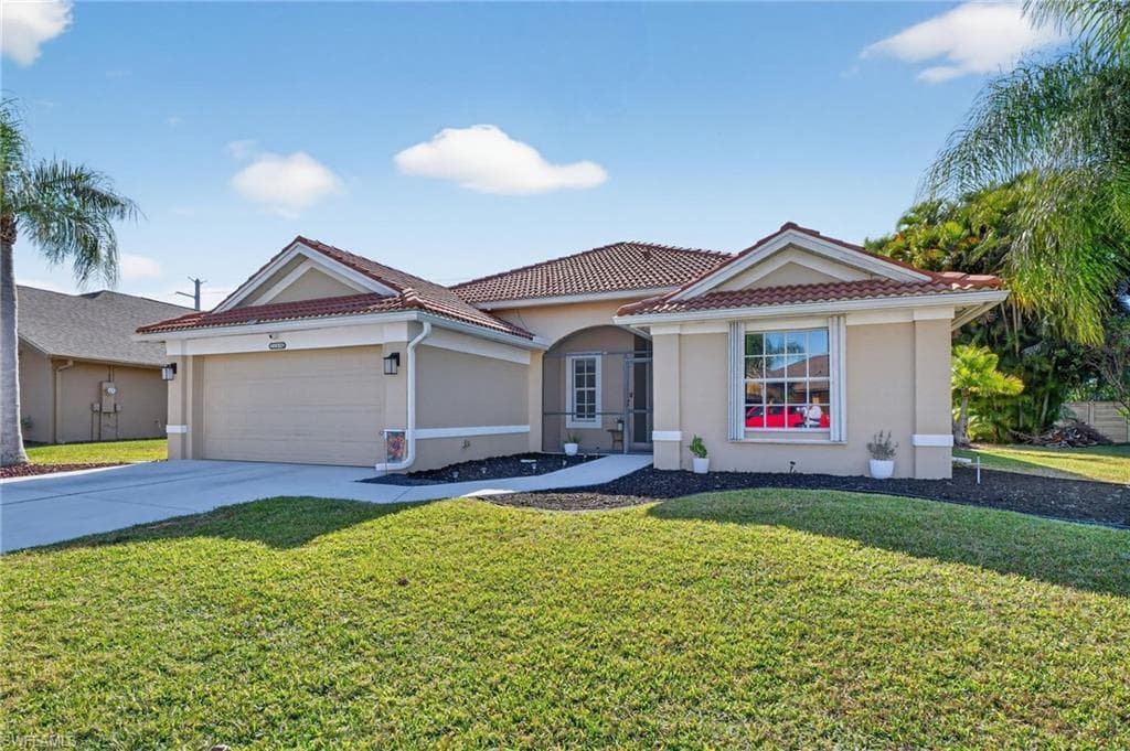View of front of house featuring concrete driveway, a front lawn, stucco siding, and a tile roof