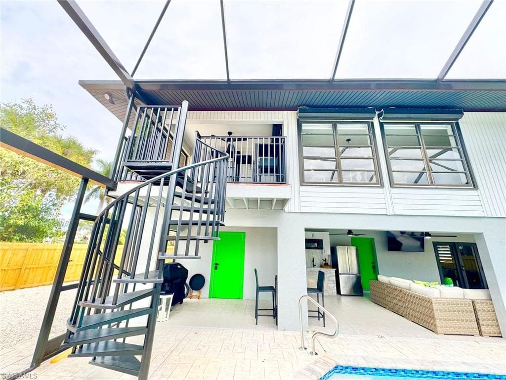 Rear view of property with an outdoor lounge area, a patio, a ceiling fan, an outdoor pool, and a sunroom