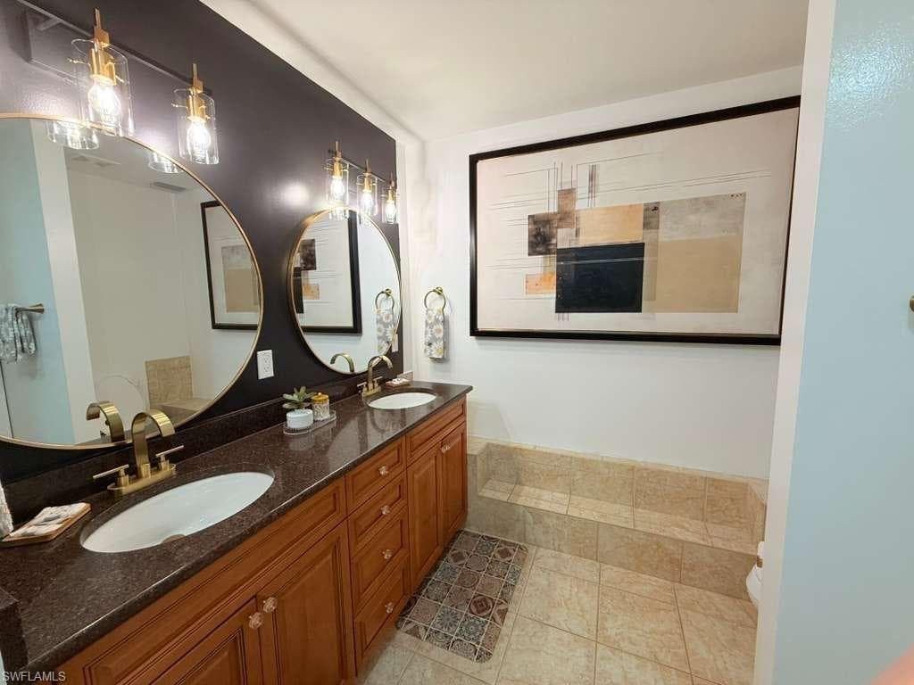 Bathroom featuring double vanity and light tile patterned floors