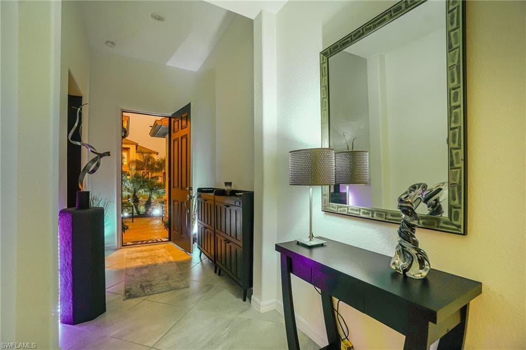 Hallway with baseboards and light tile patterned flooring