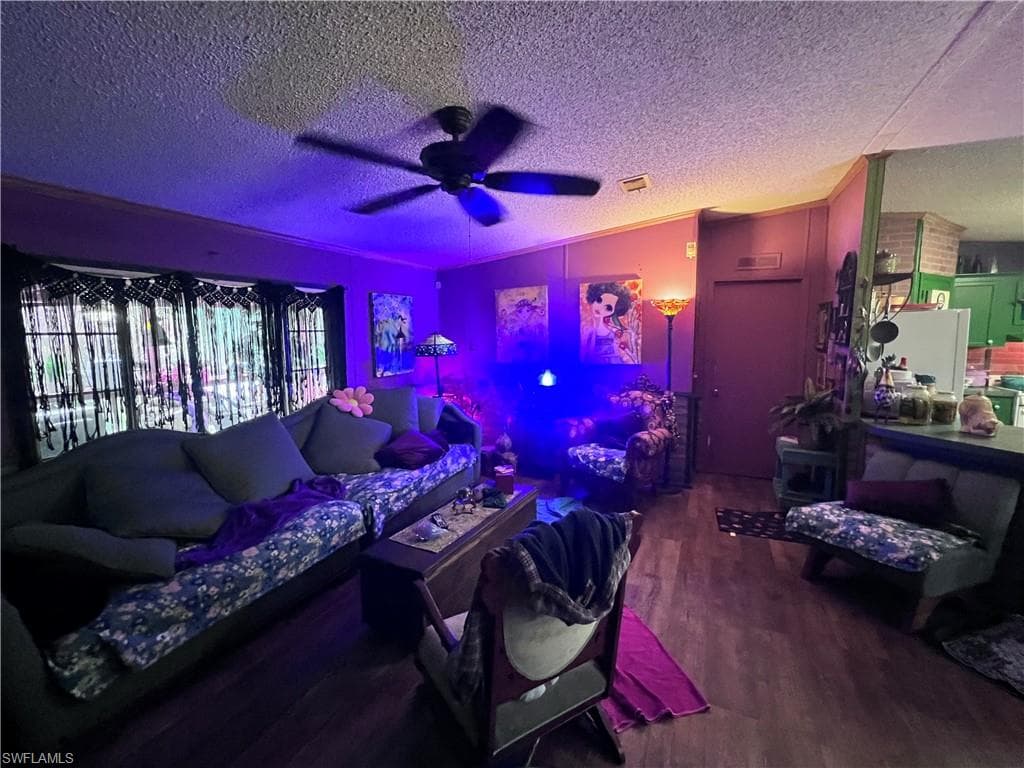 Living room with ceiling fan and dark wood finished floors