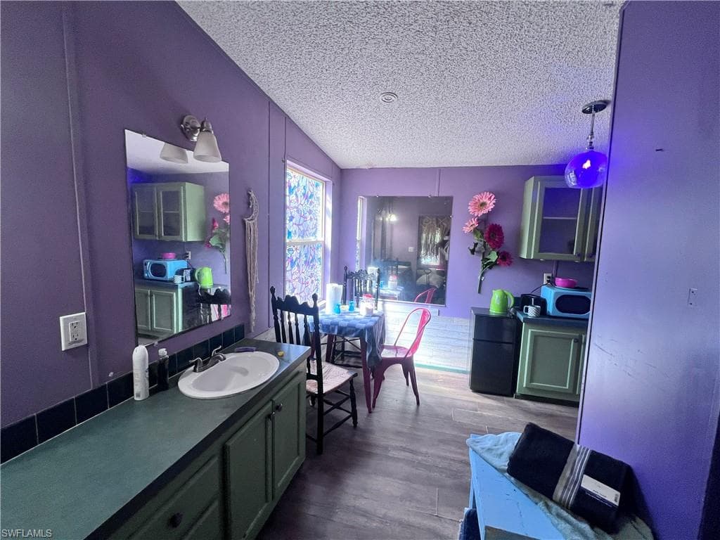 Full bathroom featuring vanity, dark wood finished floors, and a textured ceiling