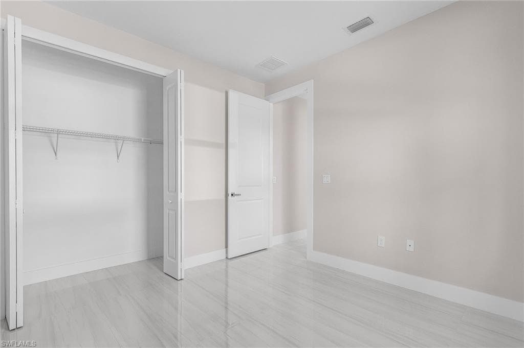 Unfurnished bedroom with baseboards and a closet