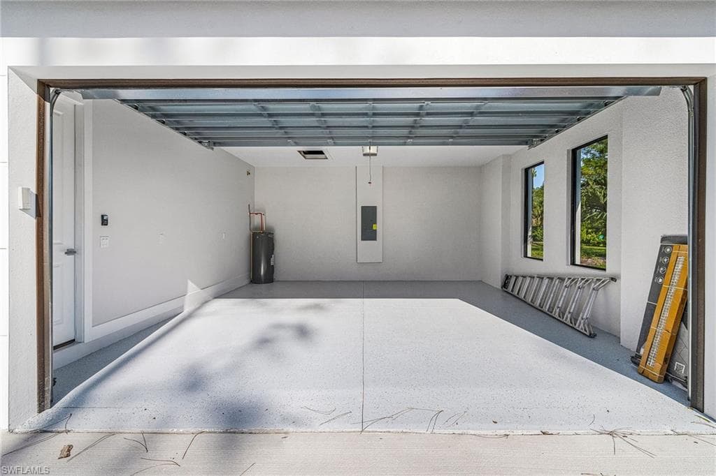 Garage featuring water heater and electric panel