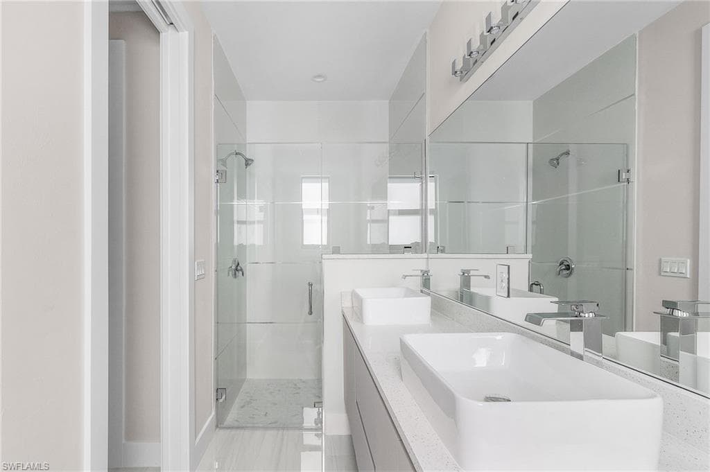 Bathroom with a shower stall and double vanity