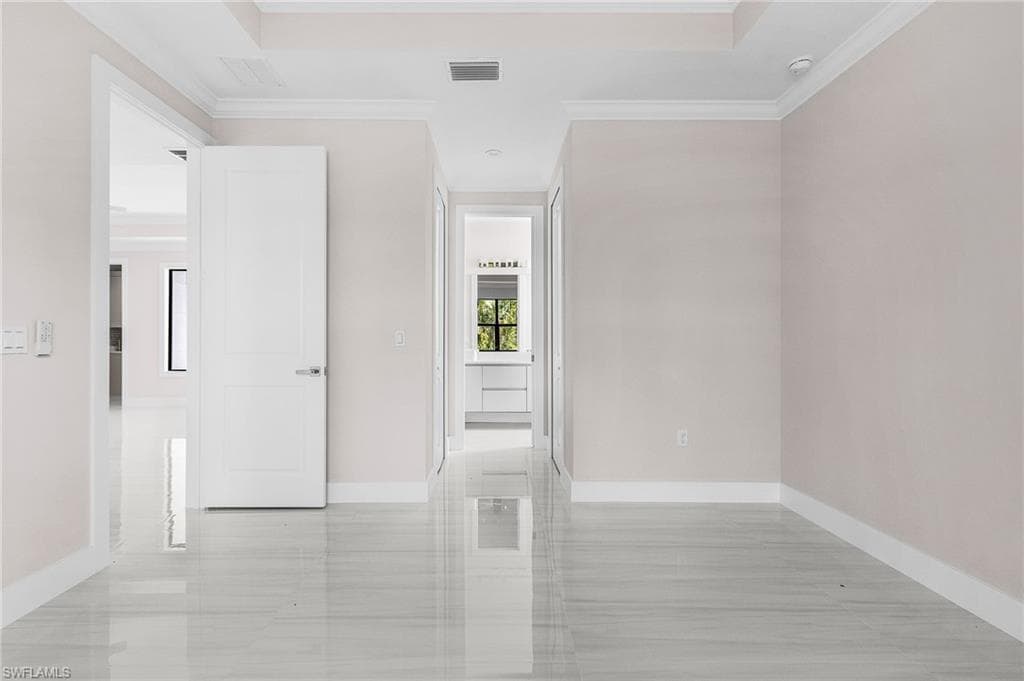 Empty room featuring crown molding