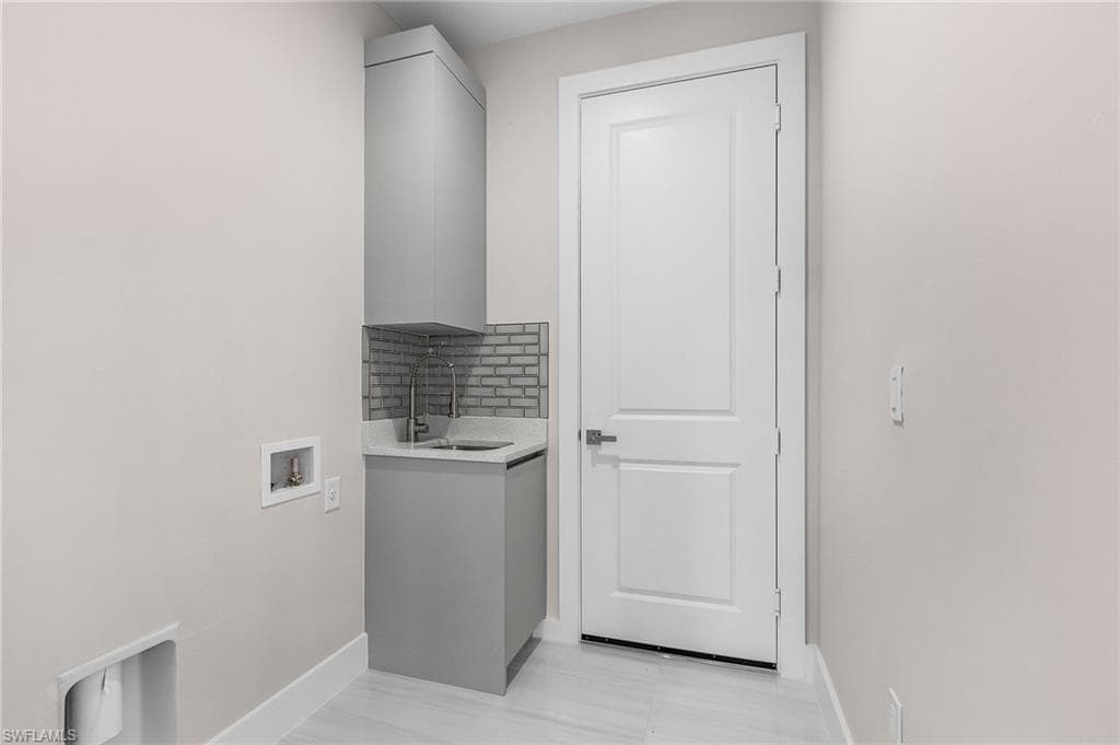 Washroom featuring baseboards and hookup for a washing machine