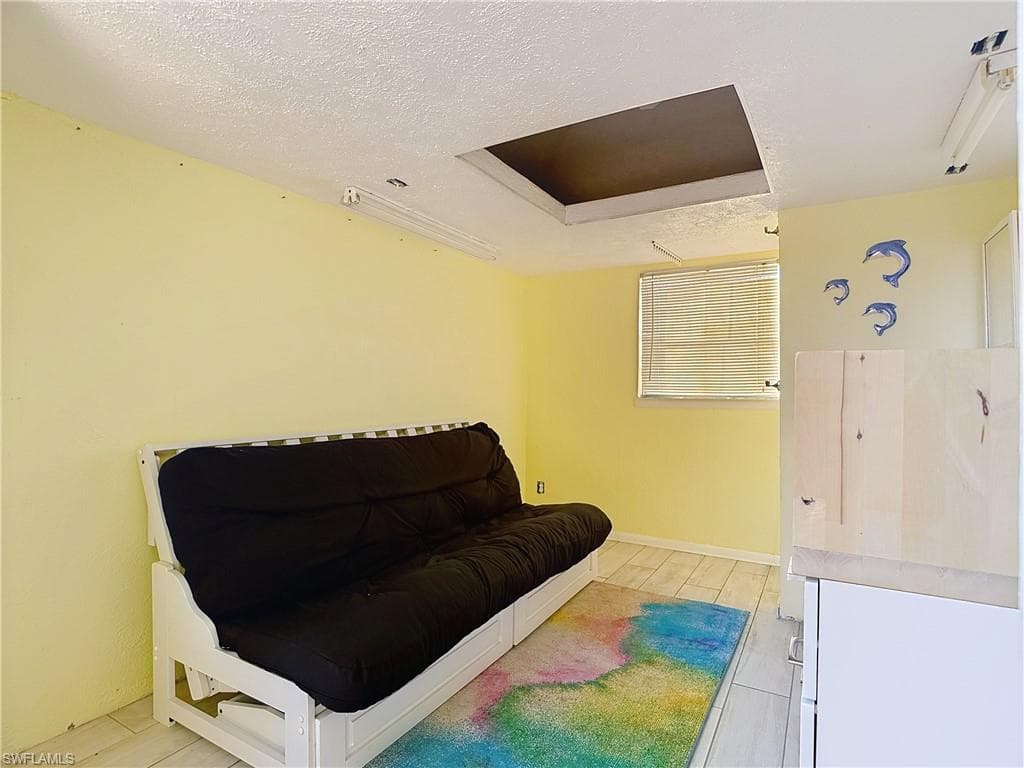 Living area with a textured ceiling and baseboards