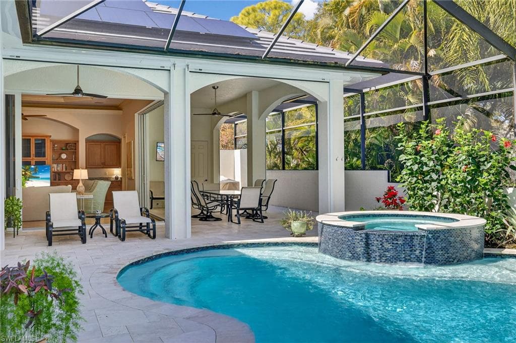Relaxing pool / spa featuring outdoor dining space, a sunroom, a patio, and a lanai
