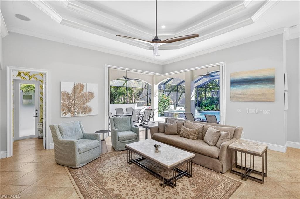 Living area featuring a sunroom, ceiling fan, light tile patterned floors, and ornamental molding