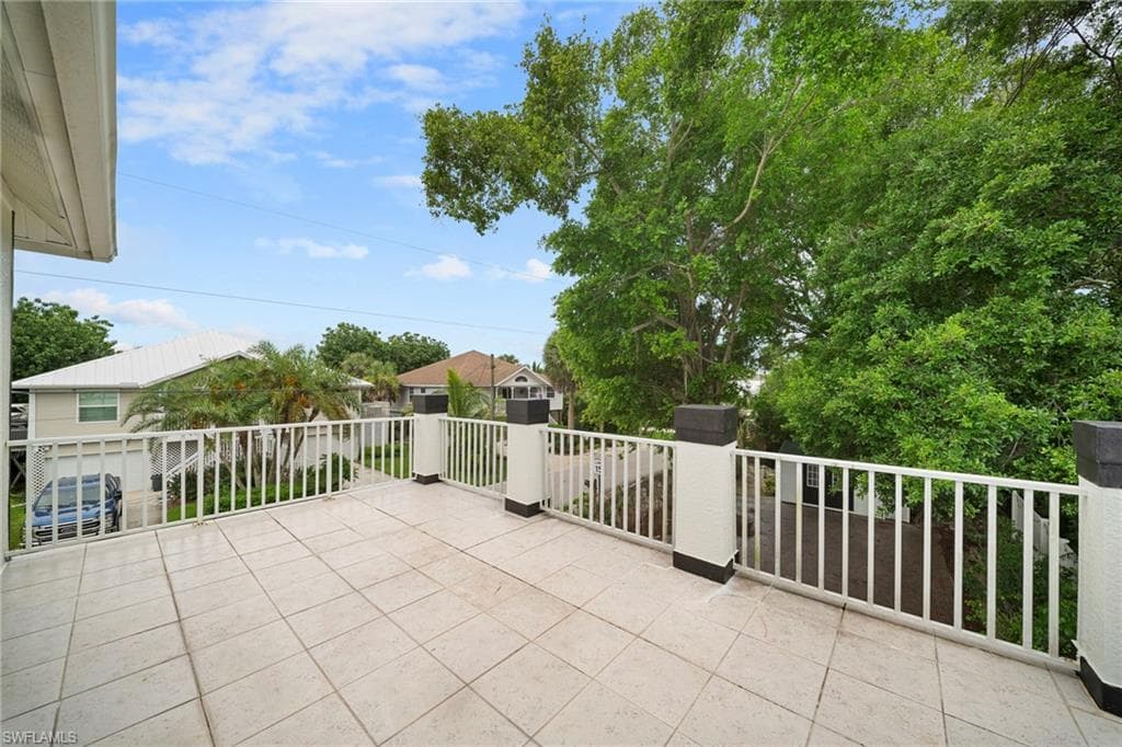 Expansive outdoor patio featuring light-toned square tile flooring and white railing