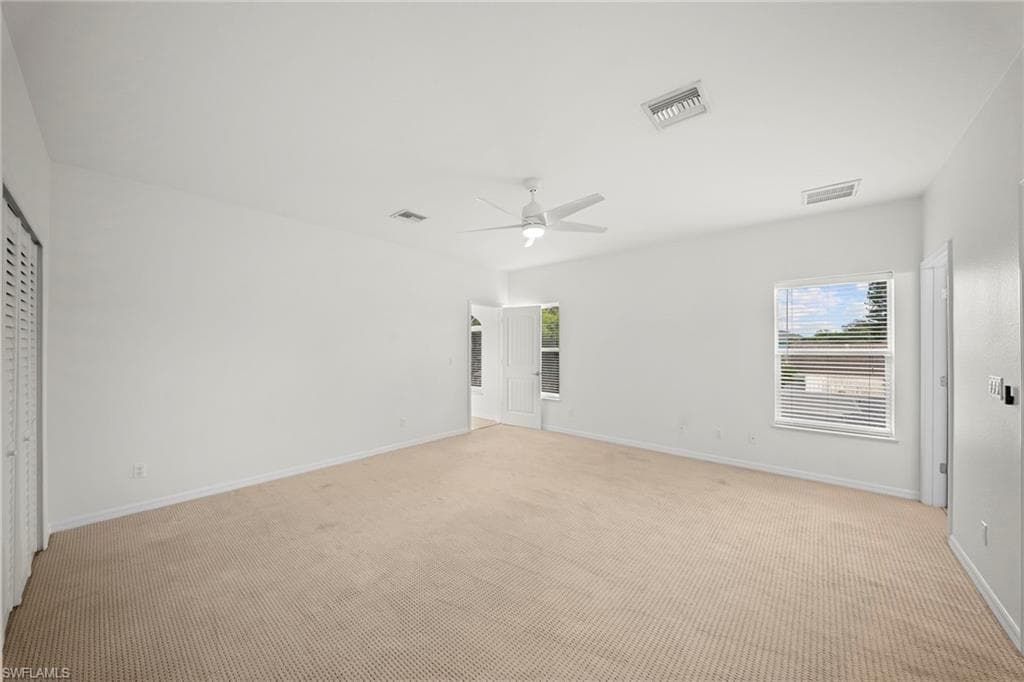 Spacious room featuring neutral carpet flooring and white walls