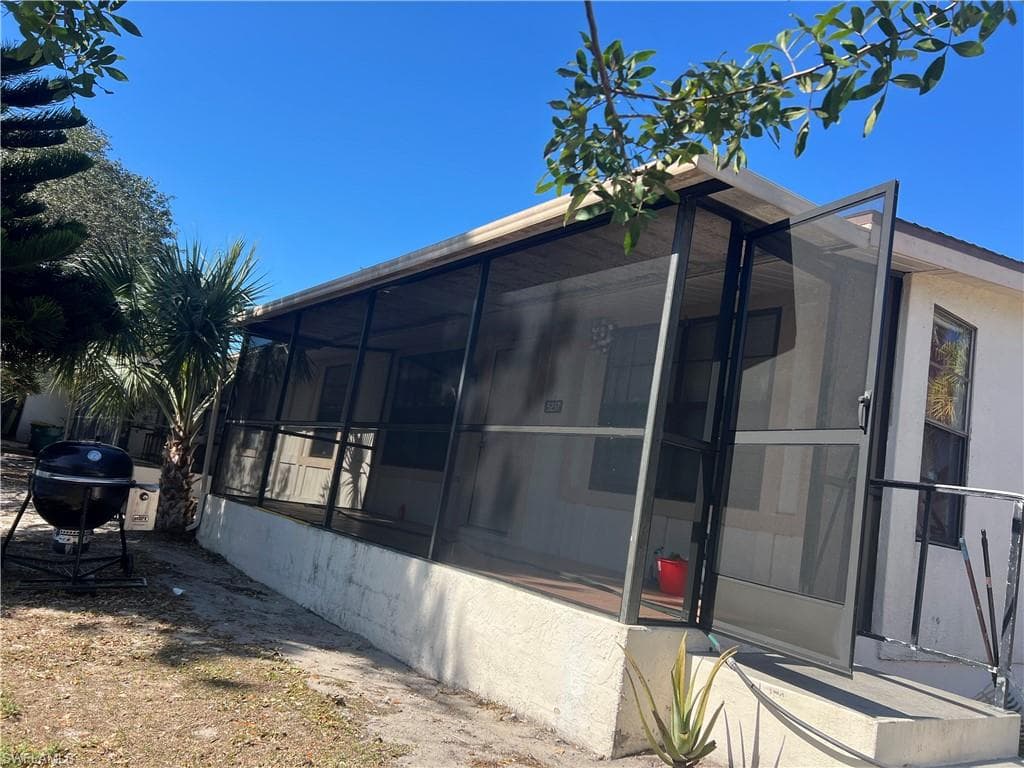 View of side of home featuring a sunroom