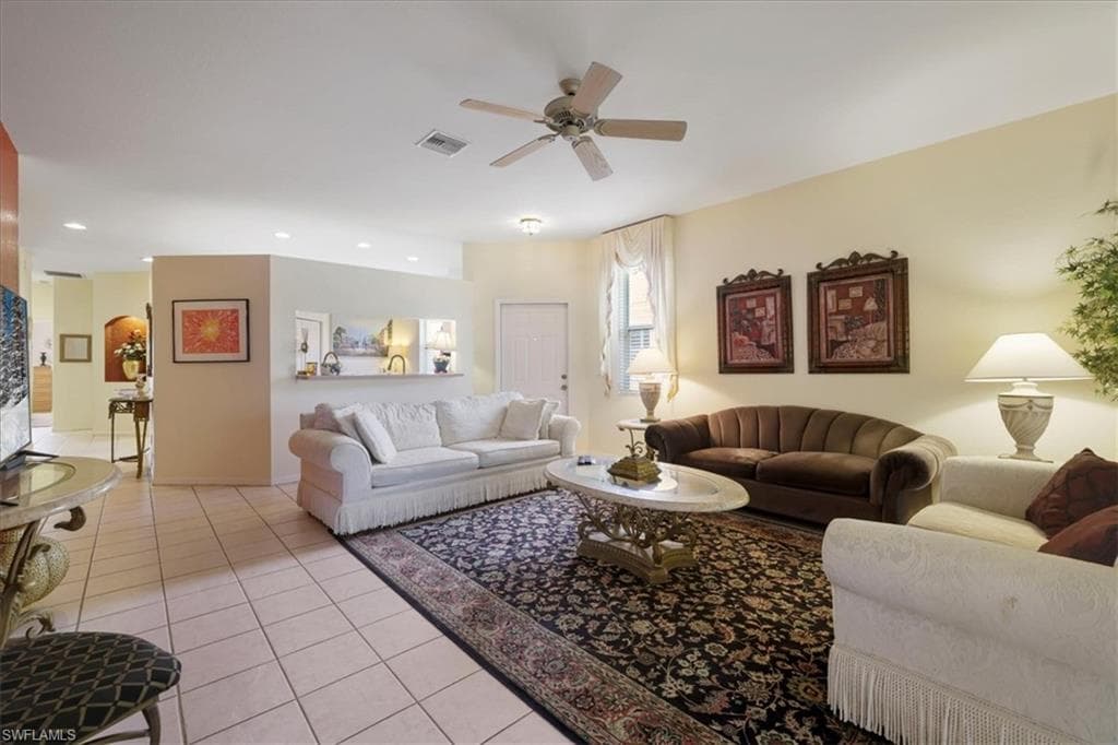 Living area with light tile patterned floors, a ceiling fan, and recessed lighting