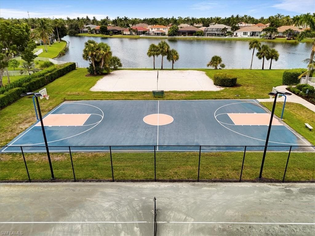 View of sport court with a lawn, community basketball court, a residential view, and a water view