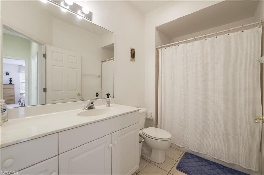 Full bathroom featuring vanity, light tile patterned floors, and shower / tub combo