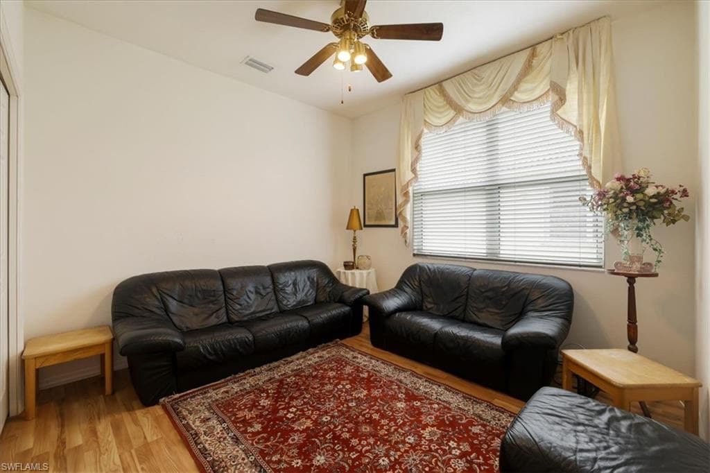 Living room with ceiling fan and light wood-style flooring