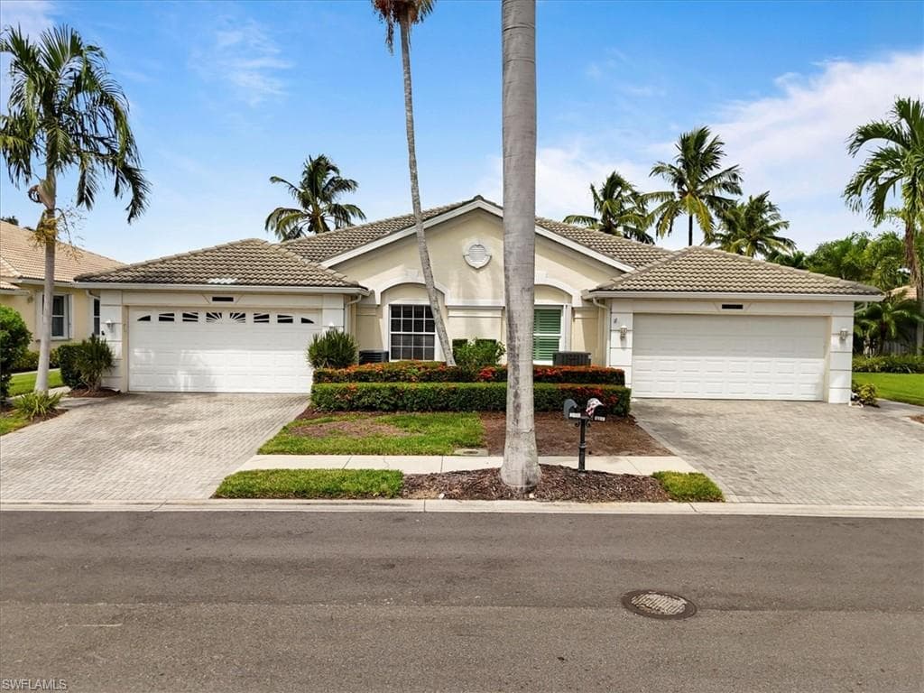 View of front of house with a garage, stucco siding, and a tile roof