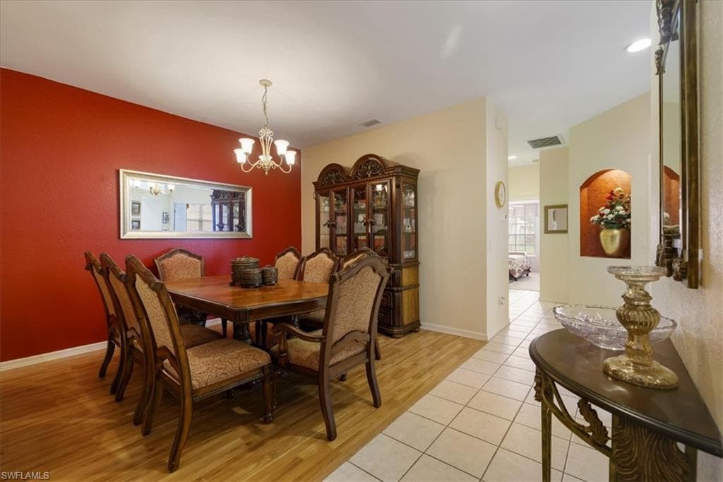 Dining area with light tile patterned flooring and suspended lighting