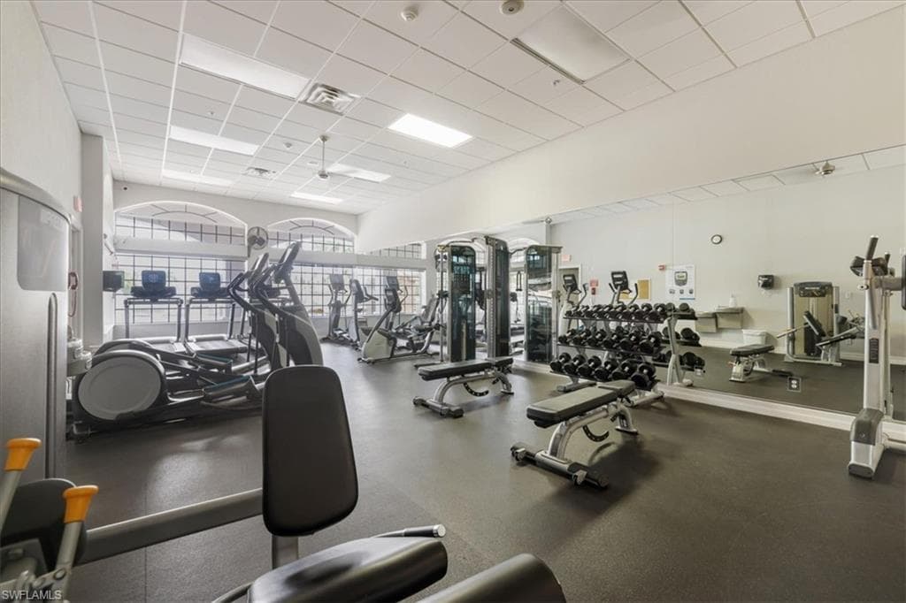 Gym with a paneled ceiling and a ceiling fan