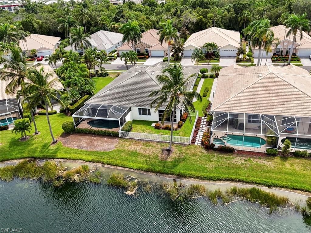 Aerial perspective of suburban area with a pool area and a large body of water