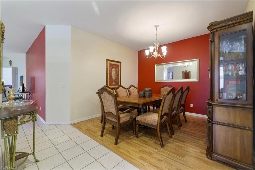 Dining room with light wood-type flooring and a chandelier