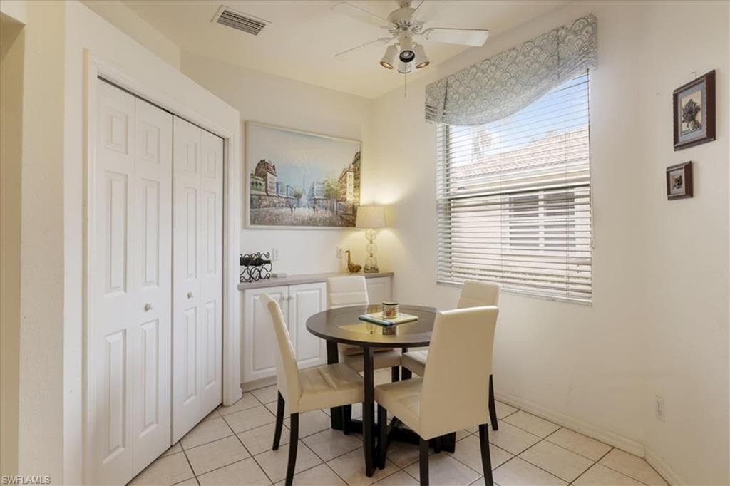Dining area with a ceiling fan and light tile patterned flooring