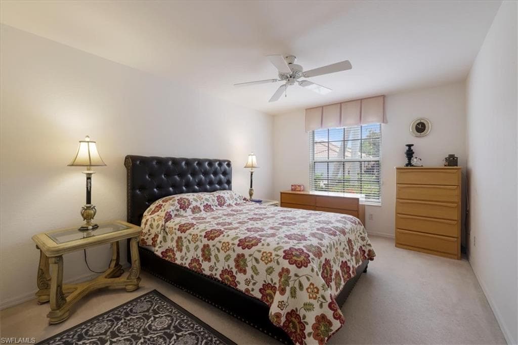 Carpeted bedroom featuring ceiling fan and baseboards