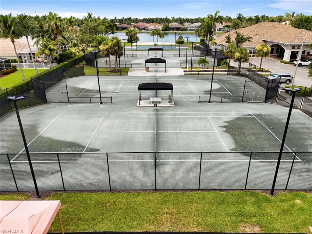 View of tennis court featuring a water view and a residential view