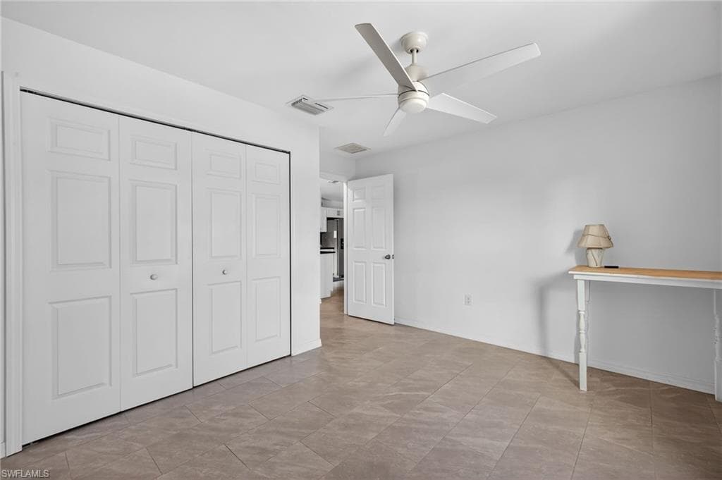 Unfurnished bedroom with a ceiling fan and a closet
