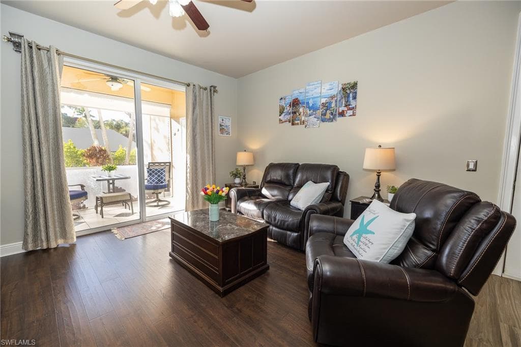 Living room with dark wood finished floors and ceiling fan