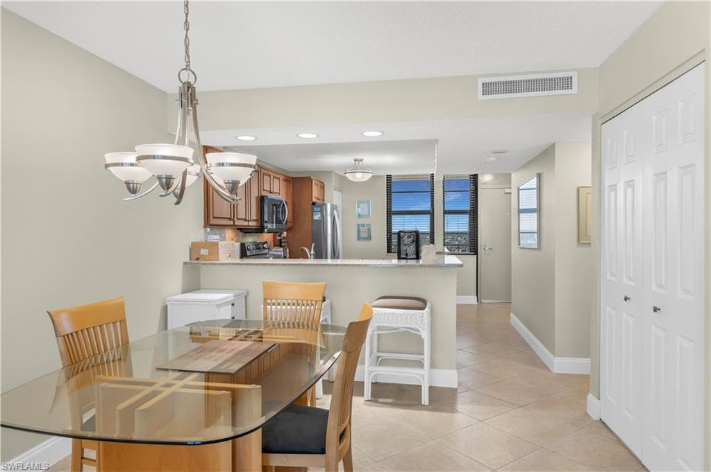 Dining room with light tile patterned flooring and suspended lighting