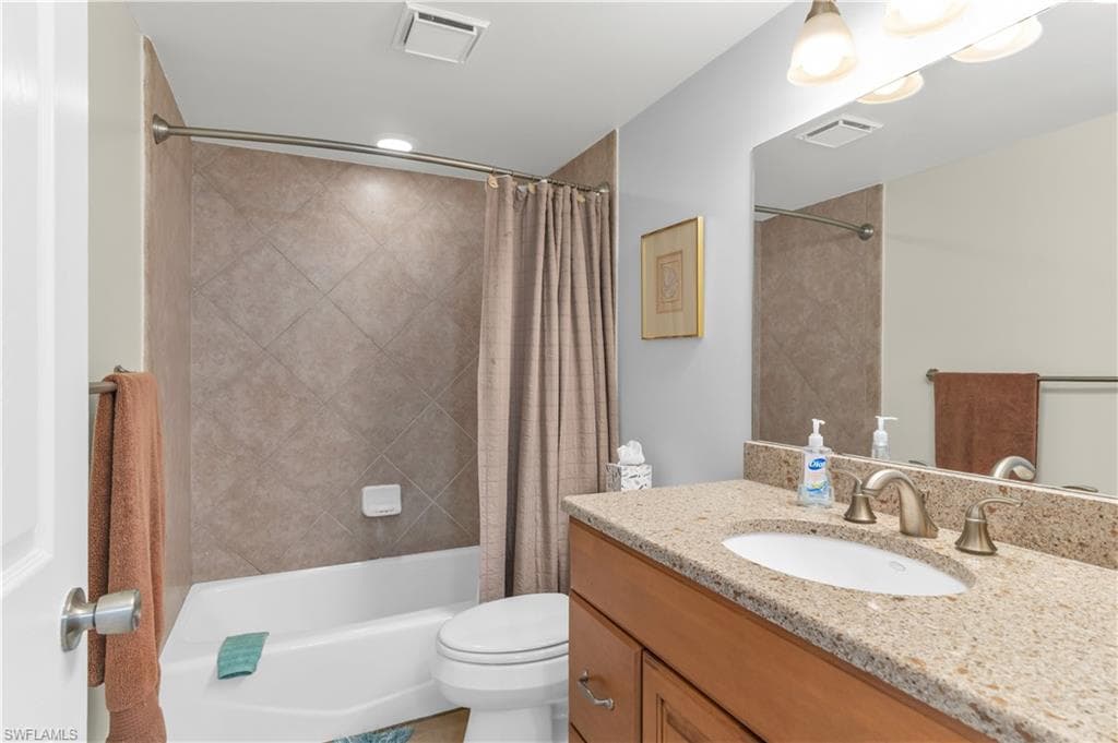Bathroom with vanity and shower / tub combo with curtain