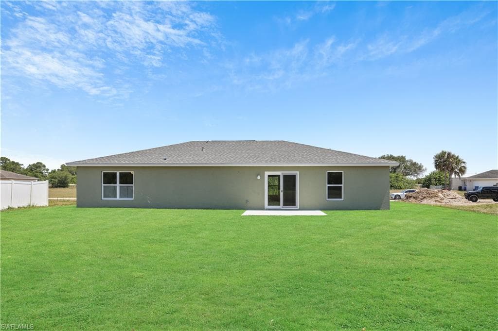 Back of property featuring a patio area, stucco siding, and a shingled roof