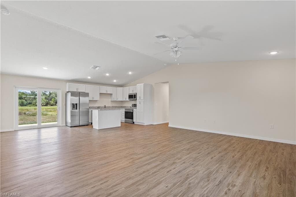 Unfurnished living room with recessed lighting, ceiling fan, lofted ceiling, and light wood-style flooring
