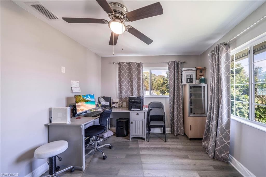Office space with wood finished floors and a ceiling fan