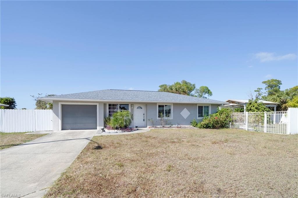 Ranch-style house with concrete driveway, a garage, and stucco siding