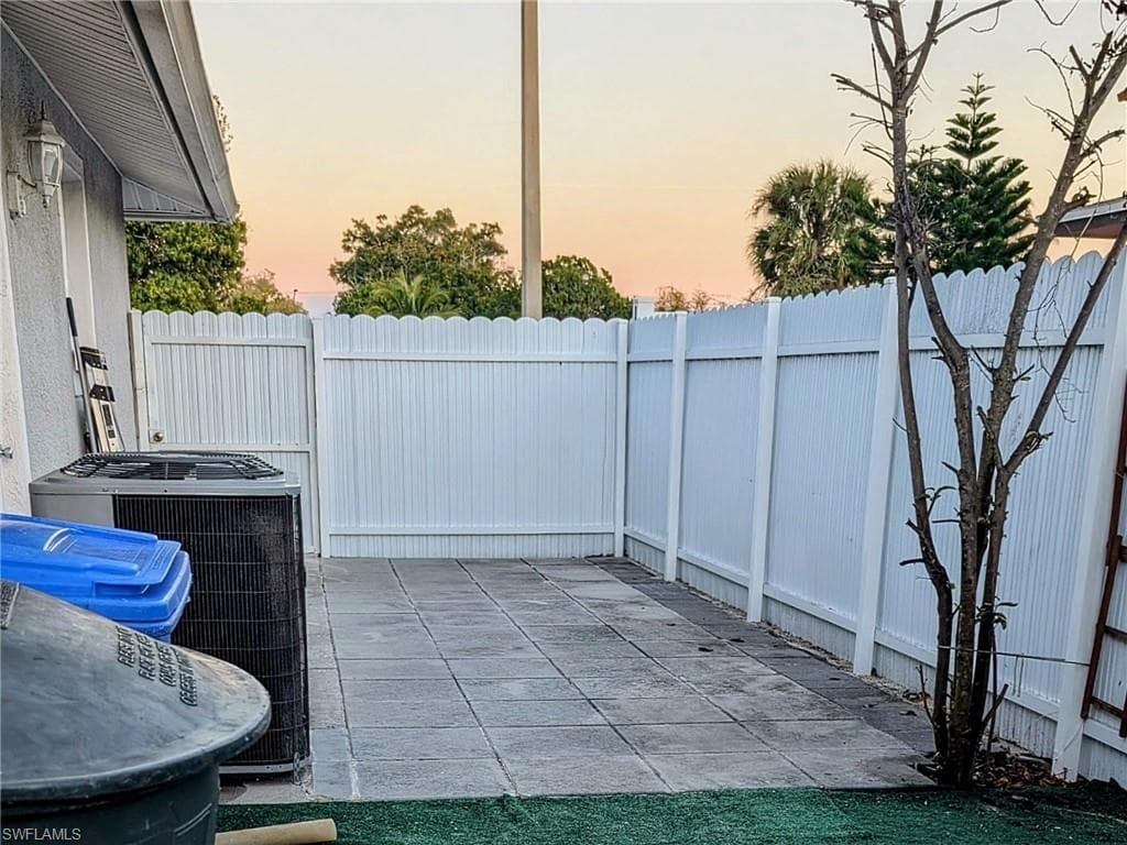 Patio terrace at dusk featuring a patio area and a fenced backyard
