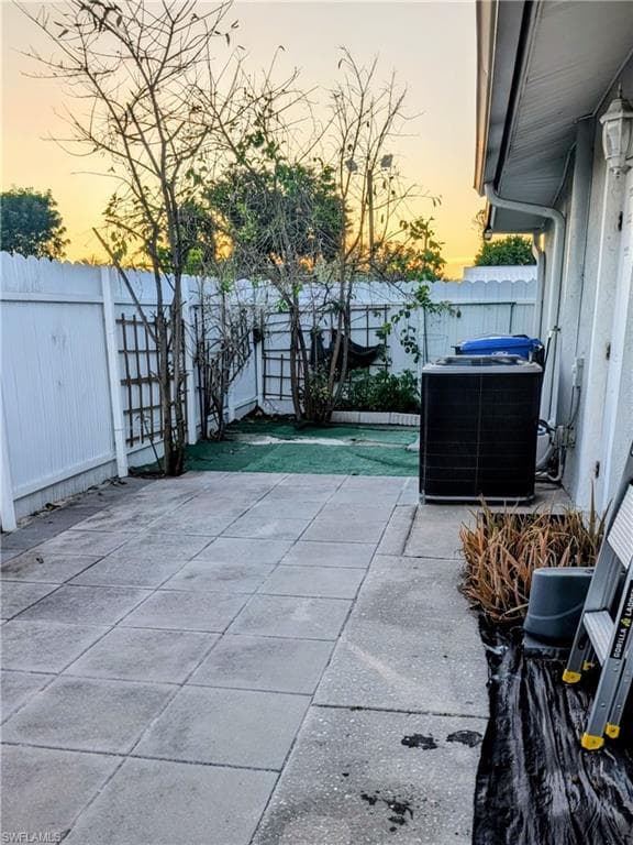 Patio terrace at dusk featuring a patio area and a fenced backyard