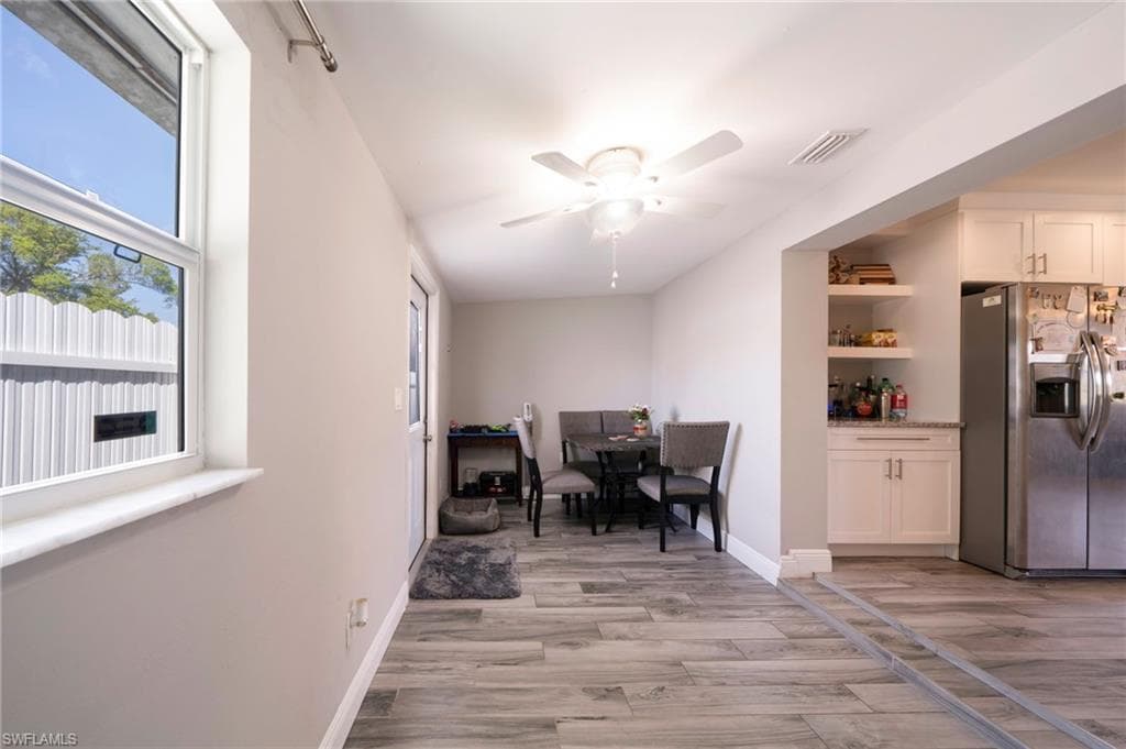 Dining area with ceiling fan and light wood-type flooring