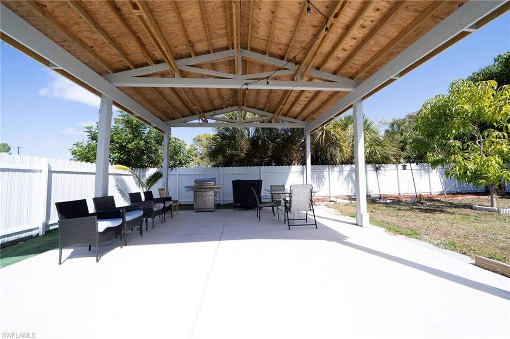 Fenced backyard featuring grilling area, a patio, and outdoor dining area
