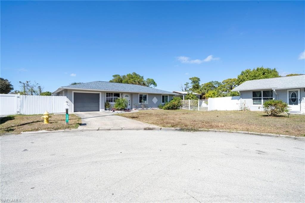 Single story home with concrete driveway and an attached garage