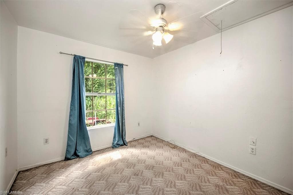 Empty room featuring light carpet and ceiling fan
