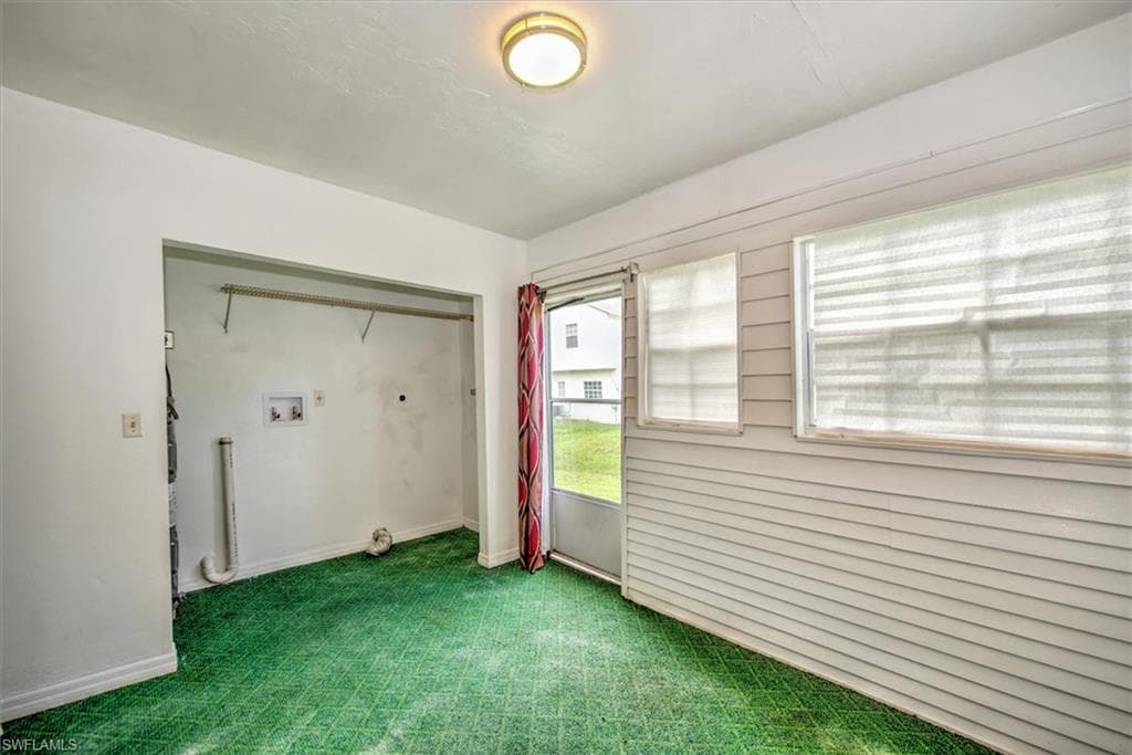 Carpeted empty room featuring baseboards