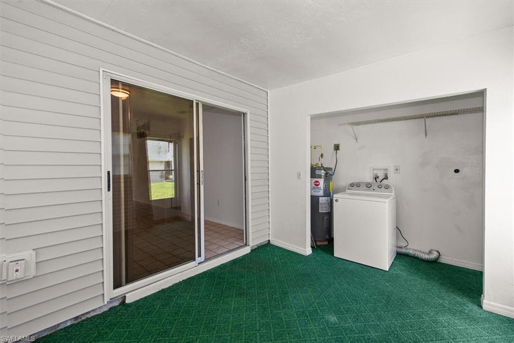 Laundry area with washer / clothes dryer, dark colored carpet, wooden walls, and electric water heater