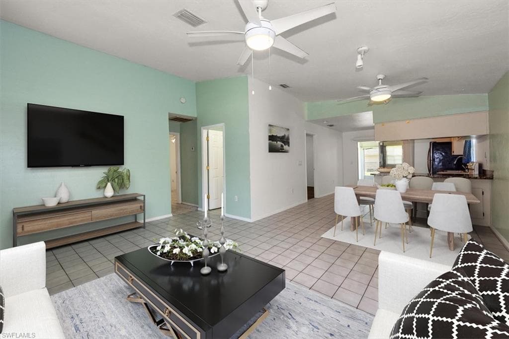 Living area with ceiling fan and light tile patterned floors