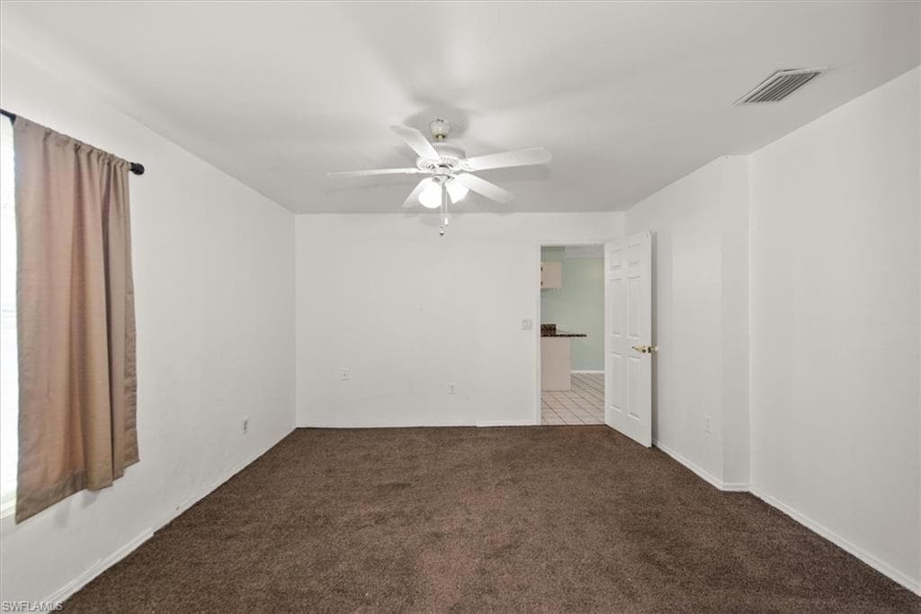 Spare room featuring ceiling fan and carpet floors