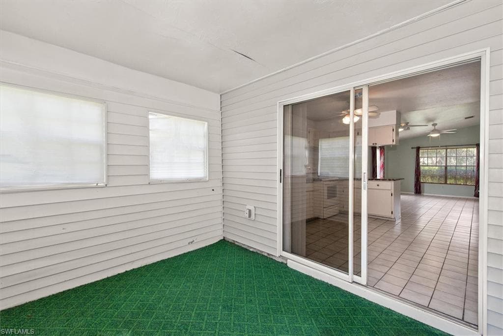 Unfurnished sunroom featuring ceiling fan