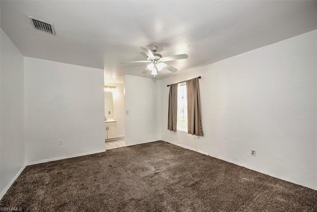 Empty room with ceiling fan and carpet floors