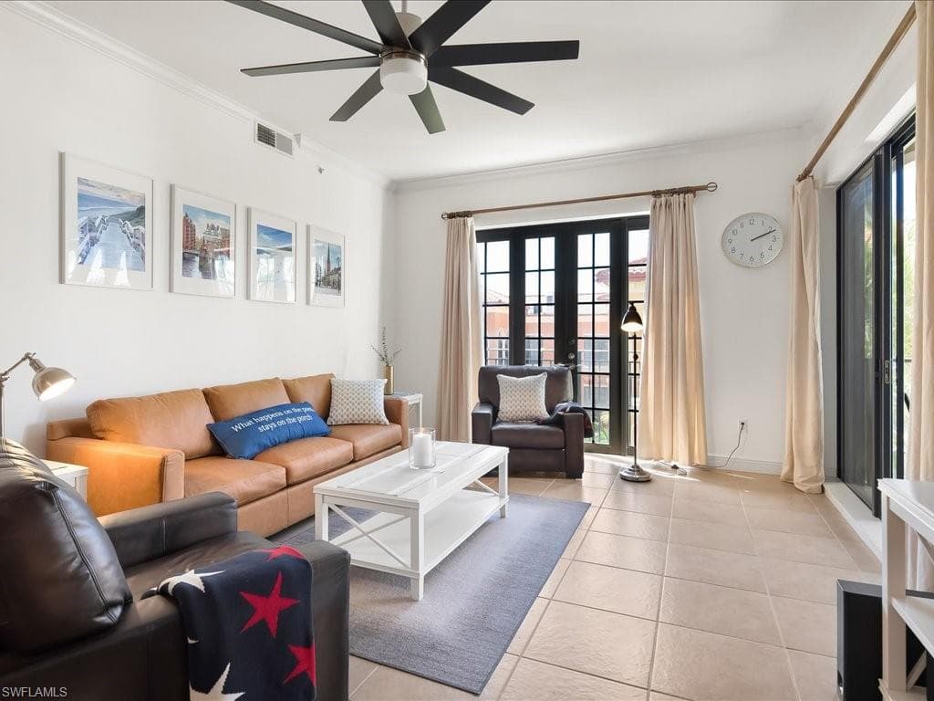 Living room with french doors, ornamental molding, light tile patterned flooring, and a ceiling fan